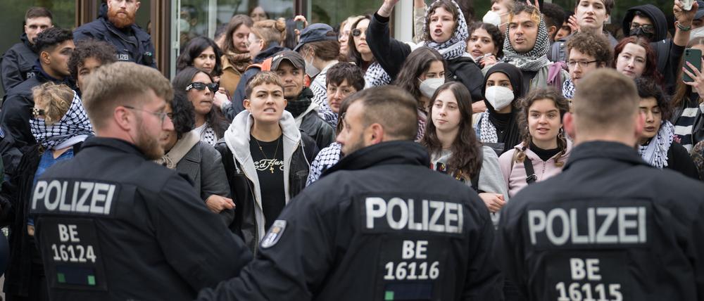Demonstranten stehen während einer propalästinensischen Demonstration der Gruppe „Student Coalition Berlin“ auf dem Theaterhof der Freien Universität Berlin vor Polizeibeamten außerhalb des Camps. 