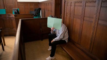 Der Angeklagte zu Beginn des Prozesses. Er verdeckte sein Gesicht mit einem Papier.