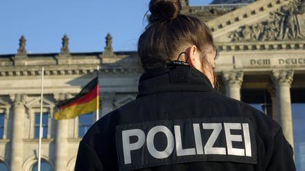 Eine Polizistin hält Wache beim Reichstag in Berlin.