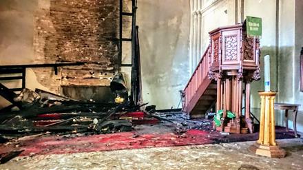 Nur noch verkohlte Holzreste. Der Altar in der Paul-Gerhardt-Kirche nach dem Brand.
