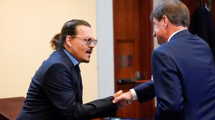 Johnny Depp schüttelt seinem Anwalt die Hand am letzten Tag des Verfahrens zwischen ihm und seiner Ex-Frau Amber Heard.
