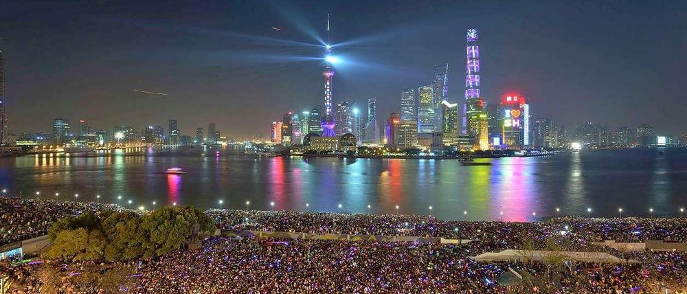 Zehntausende Menschen versammelten sich an der Hafenbauer von Shanghai und blickten auf die Silhouette von Pudong.