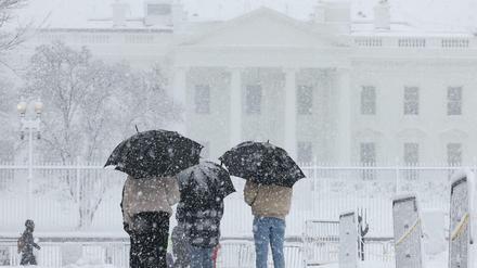 Besucher betrachten das Weiße Haus während eines Schneesturms in Washington, USA, 3. Januar 2022.
