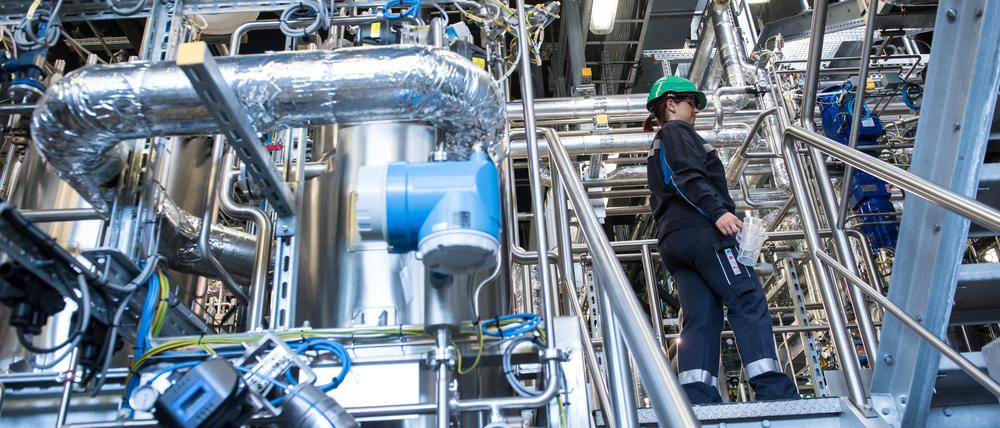 Jenny  Pietzsch, engineer of biotechnology at the demo plant of the french biotech company Global Bioenergies walks in teh demo plant during the inauguration ceremony of the demo plant in Leuna, Eastern Germany on May 11, 2017. - It is at the heart of a German petrochemical complex near Leipzig, eastern Germany, that the French  company Global Bioenergies is successfully achieving to produce isobutene, an hydrocarbon gas made from organic ressources, sugar and genetically modified bacteria. (Photo by Jens-Ulrich Koch / AFP) / TO GO WITH AFP STORY BY MARIE HEUCLIN