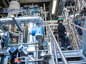 Jenny  Pietzsch, engineer of biotechnology at the demo plant of the french biotech company Global Bioenergies walks in teh demo plant during the inauguration ceremony of the demo plant in Leuna, Eastern Germany on May 11, 2017. - It is at the heart of a German petrochemical complex near Leipzig, eastern Germany, that the French  company Global Bioenergies is successfully achieving to produce isobutene, an hydrocarbon gas made from organic ressources, sugar and genetically modified bacteria. (Photo by Jens-Ulrich Koch / AFP) / TO GO WITH AFP STORY BY MARIE HEUCLIN