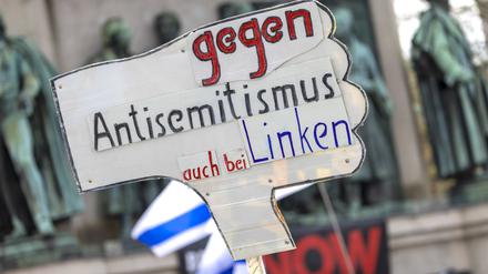 07.04.2024, Nordrhein-Westfalen, Köln: Ein Teilnehmer der Kundgebung hält ein Schild mit der Aufschrift „Gegen Antisemitismus auch bei den Linken“ hoch. 