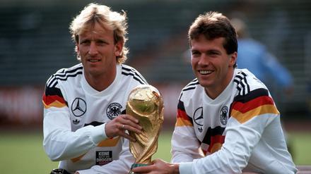 Andreas Brehme und Lothar Matthäus 1990 mit dem WM-Pokal.