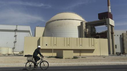 Ein Arbeiter fährt mit seinem Fahrrad vor dem Reaktorgebäude am Atomkraftwerk Buschehr (Archivbild). 