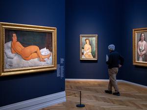 25.04.2024, Brandenburg, Potsdam: Ein Mann geht nach der Pressekonferenz zur Ausstellung «Modigliani. Moderne Blicke» im Museum Barberini an den Bildern (l-r) „Auf der Seite liegender Frauenakt (2017, Öl auf Leinwand) und „Junge Frau im Unterkleid, weiblicher Halbakt“ (1918, Öl auf Leinwand) von Amedeo Modigliani sowie „Sitzende Frau im Hemd“ (1921, Öl auf Leinwand) von Pablo Picasso vorbei. 