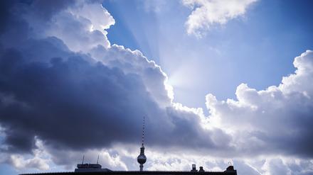 ARCHIV - 02.10.2022, Berlin: Die Sonnenstrahlen kommen hinter einer dunklen Wolke über dem Fernsehturm hervor. (zu dpa: «Wolken und Sonne am Wochenende in Berlin und Brandenburg») Foto: Annette Riedl/dpa +++ dpa-Bildfunk +++