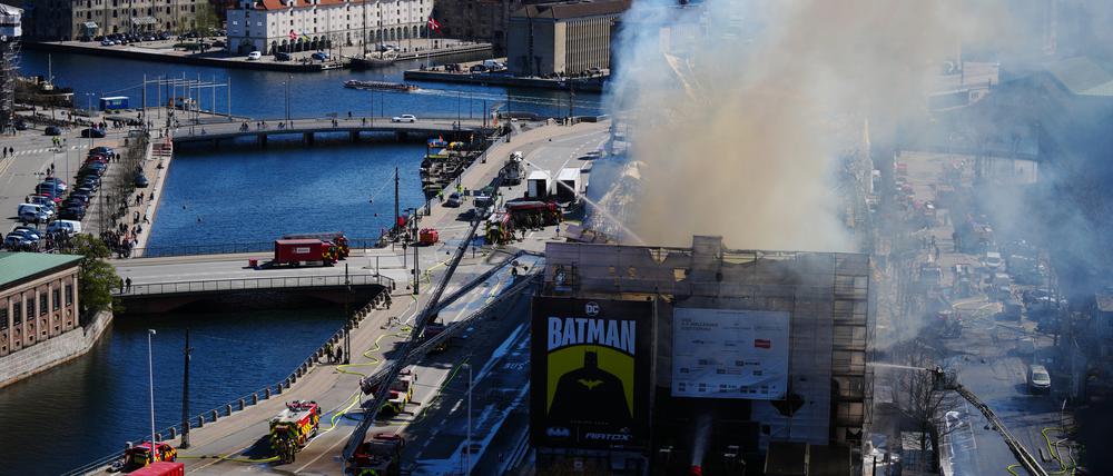 Rauch steigt aus der Alten Börse, „Boersen“ bei einem Brand in Kopenhagen auf, während die Feuerwehr den Brand bekämpft. Eines der ältesten Gebäude Kopenhagens steht in Flammen, und seine ikonische Turmspitze ist eingestürzt. 