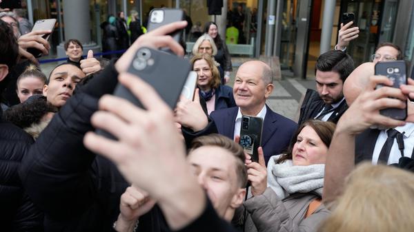 Bundeskanzler Scholz wird umringt von Jugendlichen mit ihren Handys. 