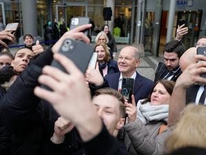 Bundeskanzler Scholz wird umringt von Jugendlichen mit ihren Handys. 