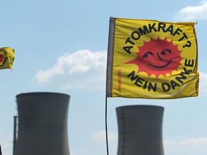 Atomkraftgegner halten am 25.04.2011 in Bergrheinfeld (Unterfranken) zwei «Atomkraft Nein Danke»-Fahnen vor die Kühltürme des Atomkraftwerks Grafenrheinfeld. 