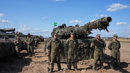 Die deutsche Besatzung eines Kampfpanzers Leopard 2A6 steht auf einem Truppenübungsplatz in Litauen