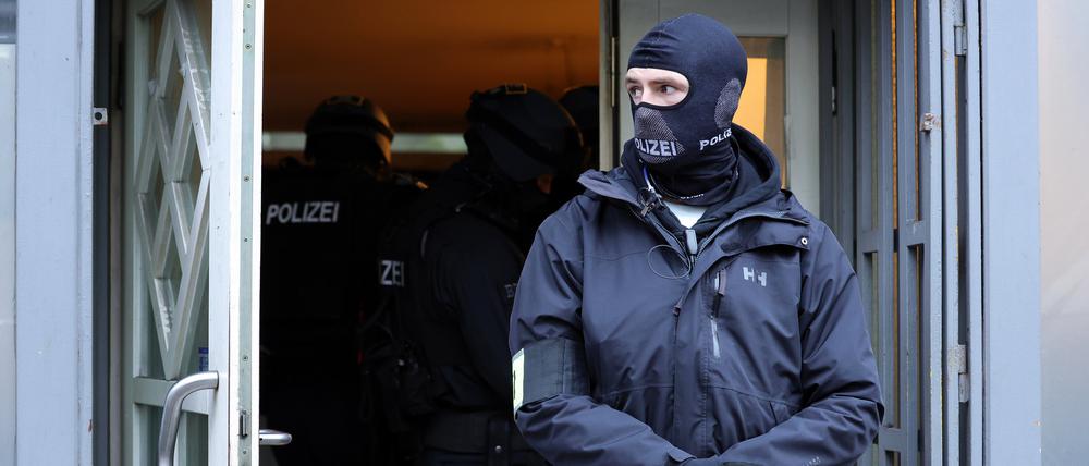Einsatzkräfte der Polizei stehen bei einer Razzia im Eingangsbereich eines Gebäudes in Solingen (NRW).