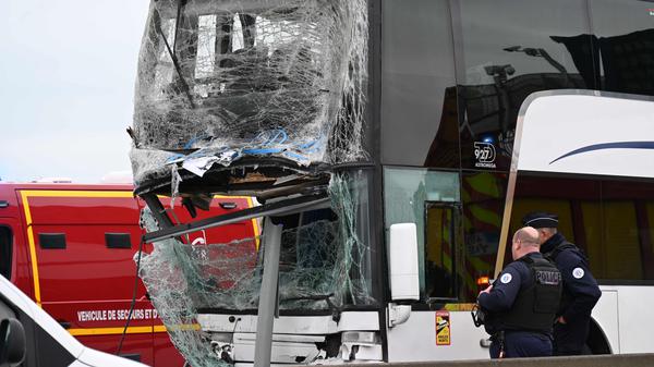 Französische Polizisten stehen an einem der verunfallten Busse.