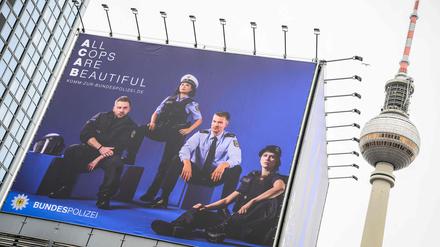 A billboard featuring a recruitment poster for Germany's federal police (Bundespolizei) is inscribed with the slogan "All Cops Are Beautiful", a play on the acronym ACAB (All Cops Are Bastards), in Berlin, on January 18, 2023, as the capital's landmark Television Tower (Fernsehturm) is seen in the background. (Photo by John MACDOUGALL / AFP)