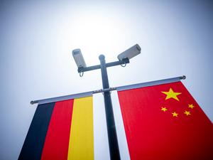 Überwachungskameras sind über der deutschen und der chinesischen Flagge vor der Tongji-Universität montiert.