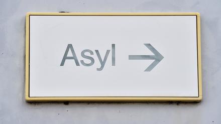 Ein Schild mit der Aufschrift „Asyl“ hängt in einer Landeserstaufnahme für Asylbewerber (LEA) an einer Wand.
