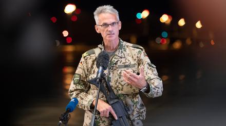 Jens Arlt, Brigadegeneral der Bundeswehr, gibt mit einem Sturmgewehr in der Hand auf dem niedersächsischen Stützpunkt Wunstorf ein Statement ab. 