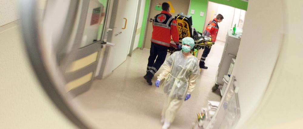 Eine Krankenschwester mit Mundschutz geht durch die Notaufnahme eines Krankenhauses.