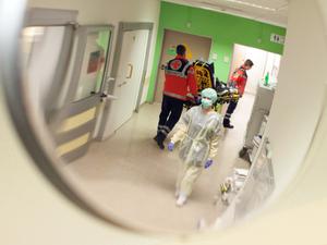 Eine Krankenschwester mit Mundschutz geht durch die Notaufnahme eines Krankenhauses.