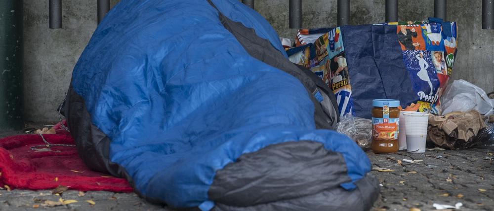 Ein Obdachloser in einen Schlafsack gehüllt unter einem Dachvorsprung vor dem Berliner Zoo. 