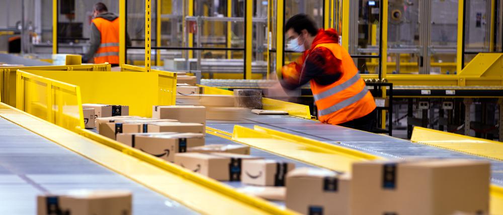 Mitarbeiter sortieren Paketsendungen des Online-Händlers Amazon in einem Verteilzentrum. 