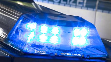 Ein Blaulicht leuchtet während eines Einsatzes auf dem Dach eines Polizeiwagens. 