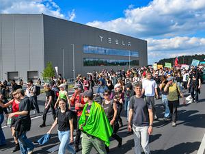 11.05.2024, Brandenburg, Grünheide: Teilnehmer einer Protestveranstaltung gehen zum Werk von Tesla. 