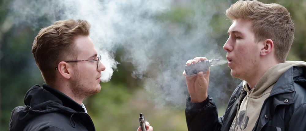 Zwei junge Menschen rauchen eine E-Zigarette. Seit Jahren sinkt die Zahl der Raucher in Großbritannien. 2022 waren es noch 12,9 Prozent der Erwachsenen. Doch Experten warnen, das Ziel eines „rauchfreien“ 2030 werde Stand jetzt deutlich verfehlt. 