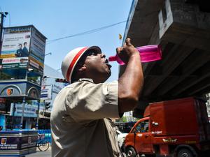 Ein Polizeibeamter aus Westbengalen trinkt während der Hitzewelle in Kolkata, Indien, Wasser.