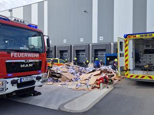 Die Potsdamer Feuerwehr bei einem Rettungseinsatz im Gewerbegebiet Friedrichspark. Einsatzkräfte entleeren gerade eine Papierpresse, in die zuvor ein Mensch geraten ist. 