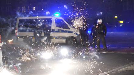 Polizeibeamte stehen hinter explodierendem Feuerwerk (Symbolbild).