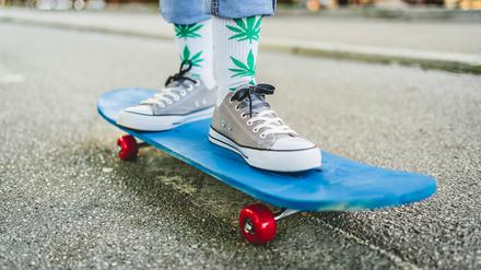 Young woman with marijuana socks on a skateboard