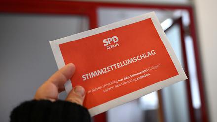 Ein Stimmzettelumschlag wird bei der Übergabe der Wahlbriefe zur SPD-Mitgliederbefragung an die Deutsche Post in die Kamera gehalten