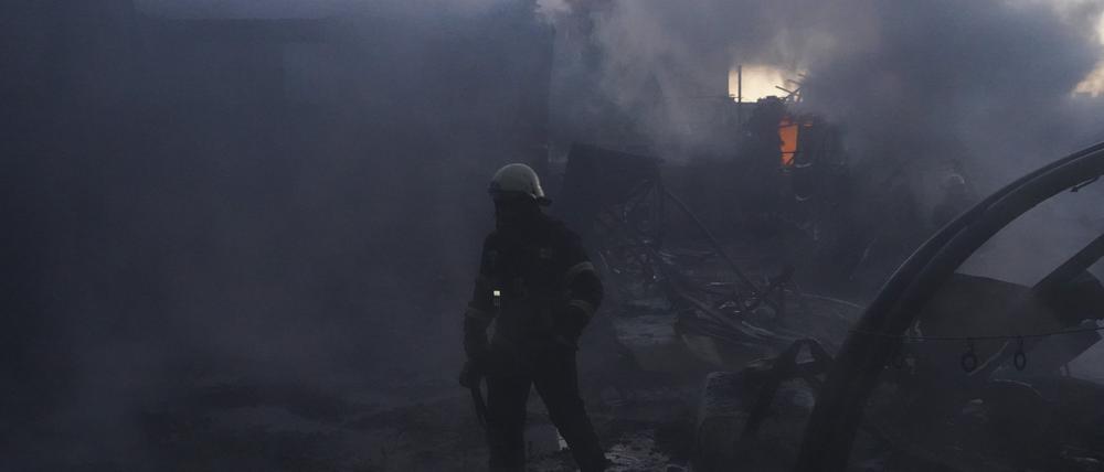Feuerwehrleute versuchen, das Feuer nach einem Treffer durch russischen Granatenbeschuss in Charkiw zu löschen.