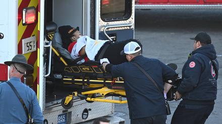 Sanitäter laden eine Frau nach einer Schießerei bei der Super Bowl LVIII-Siegparade der Kansas City Chiefs in einen Krankenwagen.
