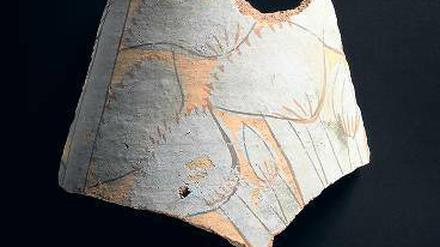 Fragment eines Gefäßes Neues Reich, 18. Dynastie, 1351-1334 v. Chr.; blau bemalte Keramik mit floralen Motiven. Schenkung James Simon. Das typische Amarna-Blau ist deutlich zu erkennen, aber auch die Schäden an der Oberfläche. 