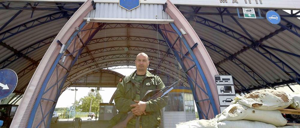 Ein Bewaffneter steht vor einem Grenzübergang zwischen der Ukraine und Russland.