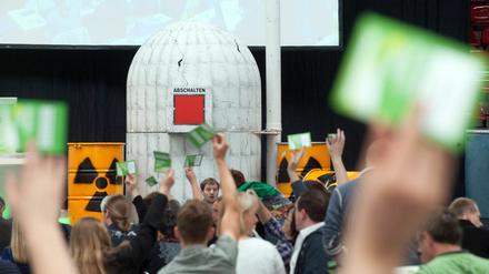 Delegierte stimmen auf dem Landesparteitag der nordrhein-westfälischen Grünen symbolisch vor einem Papp-Atomkraftwerk und einem roten "Abschalten"-Knopf ab.
