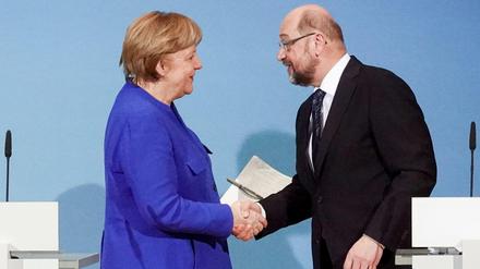 Martin Schulz, Vorsitzender der Sozialdemokratischen Partei Deutschlands (SPD) und Angela Merkel, Bundeskanzlerin und Vorsitzende der Christlich Demokratischen Union (CDU), reichen sich am 12.01.2018 am Ende der Sondierungen von Union und SPD im Willy-Brandt-Haus in Berlin die Hände.
