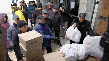 Im ostukrainischen Donezk nehmen Einwohner angelieferte Hilfsgüter in Empfang. 
