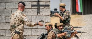 Ein Bundeswehrsoldat und kurdische Peschmerga-Kämpfer im nordirakischen Erbil.