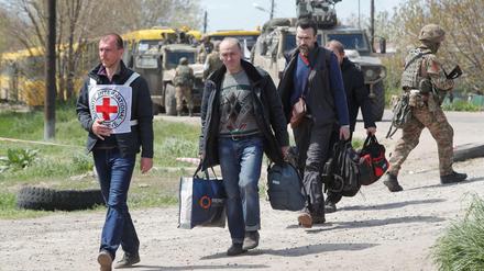 Zivilisten gehen in Begleitung eines Mitglieds des Internationalen Komitees vom Roten Kreuz (IKRK) in einem provisorischen Unterbringungszentrum im Dorf Bezimenne in der Region Donezk.