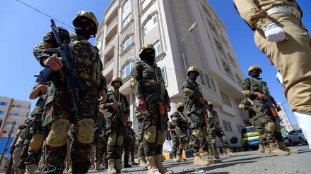 In Sanaa steht eine Reihe an Soldaten auf einer Straße. 