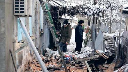 Einschläge. Bewohner eines bei Gefechten beschädigten Hauses in der ostukrainischen Stadt Donezk untersuchen die Auswirkungen der Angriffe. 