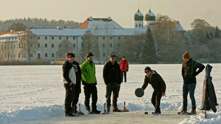 Eisstockschützen gehen am Dienstag vor der Kulisse des Klosters Seeon ihrem Sport nach. 