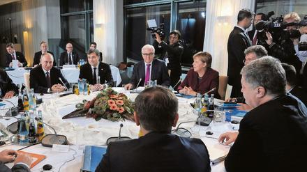 Krisengespräche am runden Tisch in Berlin, mit Wladimir Putin (l.) und Petro Poroschenko (vorn r.).